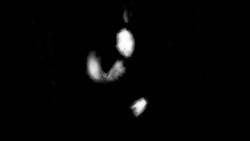 Abstract black and white image with blurred illumination that resembles the curvature of a human figure in a dynamic pose with their vague shape of their hands and head visible, extending movements into gesture calligraphy.