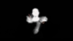 Blurred image of a person against a black background, making it difficult to discern details.