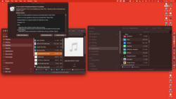 Screenshot of a MacOS desktop interface with multiple overlapping windows open, including a Finder window showing a list of applications, a pop-up notification about a software update for 'Keyboard Maestro', and a small preview of an MP3 file labeled 'upgrade device 1.mp3' selected. The desktop background is red, various folders and files lie on the right side of the desktop, and the Dock is visible on the right side with various application icons.